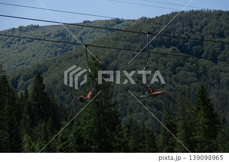 Scenic empty chairlift ride above a vibrant mountain forest Scenic empty chairlift ride above a vibrant mountain forest 139098965