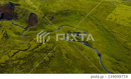 Aerial View of a Winding River in a Moss Covered Volcanic Landscape 139099759