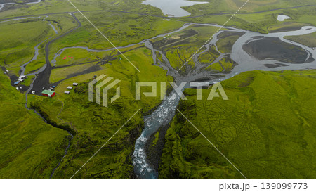 Aerial View of Icelandic River, Waterfall, and Red Roofed Building 139099773