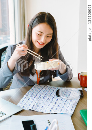 オフィスでお弁当を食べるビジネスウーマン オフィスでお弁当を食べるビジネスウーマン 139100091
