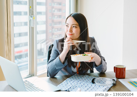 オフィスでお弁当を食べるビジネスウーマン オフィスでお弁当を食べるビジネスウーマン 139100104