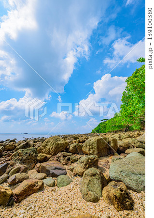 青空と白い雲に彩られた石垣島大崎ビーチの岩場が続く海辺風景 139100380