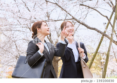 桜並木の下で満開の桜を見上げる二人の新入社員の女性・春のフレッシャーズイメージ 139100830