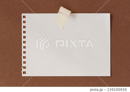 Paper sheet from notebook with perforation holes fixed by adhesive tape on cardboard surface, copy space for text, message, design layout and template use, paper mockup. Natural background 139100938