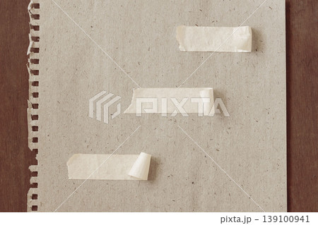 Torn notebook paper sheet with masking tape strips on wooden table, paper mockup template for note design, message space. Natural background with recycled texture, scrapbook backdrop, copy space Torn notebook paper sheet with masking tape strips on wooden table, paper mockup template for note design, message space. Natural background with recycled texture, scrapbook backdrop, copy space 139100941