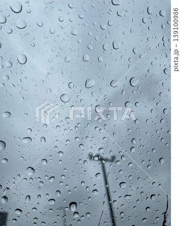 雨の日の窓ガラスに付いた水滴と曇り空の背景テクスチャ素材 139100986