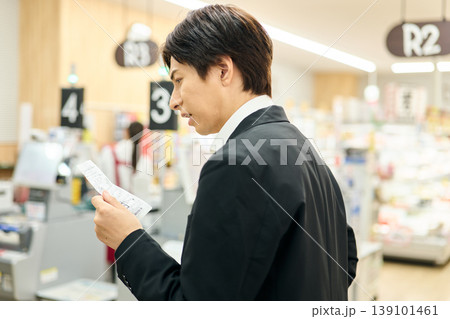 レシートの値段を見て不満を抱く男性 139101461