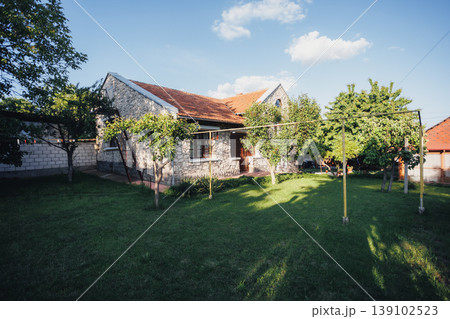 Spacious Neighborhood Lawn With Scattered Trees And Distant Houses Under Blue Sky, Clothesline And Open Green Area Conveying Weekend Serenity Suited For Community, Lifestyle, Outdoor 139102523