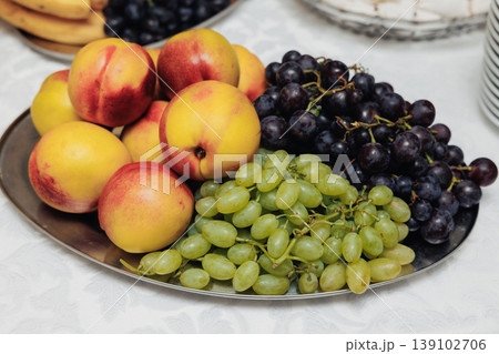 Assorted Ripe Peaches And Grapes Presented For Stylish Brunch Setting. Vibrant Seasonal Fruits Including Peaches And Grapes Beautifully Arranged On Elegant Silver Plate For Brunch Assorted Ripe Peaches And Grapes Presented For Stylish Brunch Setting. Vibrant Seasonal Fruits Including Peaches And Grapes Beautifully Arranged On Elegant Silver Plate For Brunch 139102706