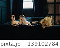 Ivory Bridal Shoes On Velvet Chaise, Cream Bouquet Beside Heels With Lace And Silk Ribbon Warm Window Light, Soft Shadows, Intimate Hotel Suite Morning, Bride Preparing Accessories, Vintage 139102784