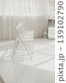 Sunlit White Folding Chairs Lined In Minimalist Studio With Sheer Curtains, Tiled Floor And Long Cast Shadows, Awaiting Ceremony Or Intimate Workshop, Clean Aesthetic, Gentle Textures, Calm 139102790