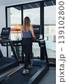 Woman Running On Treadmill Overlooking Pool, Sunlit Gym, Relaxed Cardio, Resortstyle Window View, Swim Area Visible, Casual Training Attire, Steady Pace, Cardio Monitoring Display, Wellness 139102800