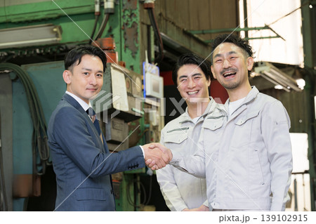 製造業の工場で握手する営業マンと作業員の信頼関係ビジネス契約や合意シーン　業務提携、協力、融資などの 139102915