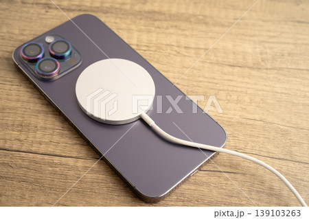 Bangkok, Thailand, January 10, 2024 Wireless charger on mobile phone, magnetic charging modern equipment of mobile phone. Bangkok, Thailand, January 10, 2024 Wireless charger on mobile phone, magnetic charging modern equipment of mobile phone. 139103263