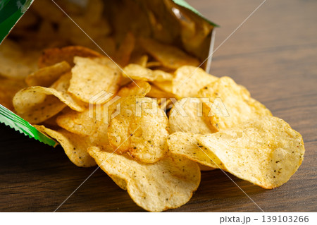 Potato chips, delicious spicy for crips, thin slice deep fried snack fast food in open bag. Potato chips, delicious spicy for crips, thin slice deep fried snack fast food in open bag. 139103266