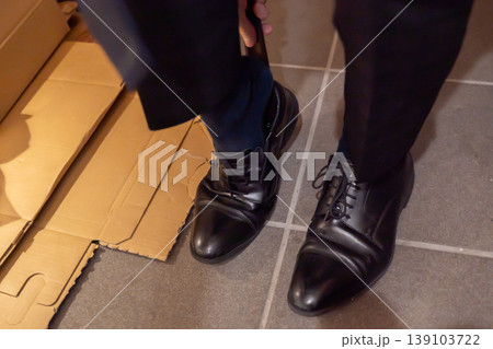 玄関で革靴を履くスーツの男性 玄関で革靴を履くスーツの男性 139103722