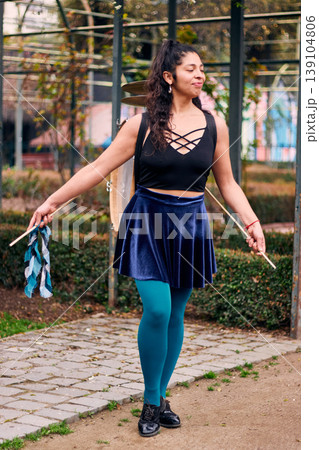 Beautiful Chilean Latina woman smiling with attitude, with her drum and cymbals on her back, detail of her musical instrument, female percussionist, street musician, dancing and playing her drum  139104806
