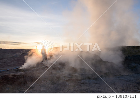 Awe inspiring sunrise at Sol de Manana with geyser steam and person Awe inspiring sunrise at Sol de Manana with geyser steam and person 139107111