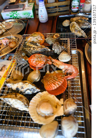 網焼きで楽しむ新鮮な魚介類、ホタテやサザエの浜焼き 139107317