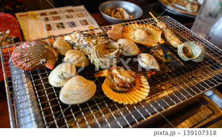 網焼きで楽しむ新鮮な魚介類、ホタテやサザエの浜焼き 網焼きで楽しむ新鮮な魚介類、ホタテやサザエの浜焼き 139107318