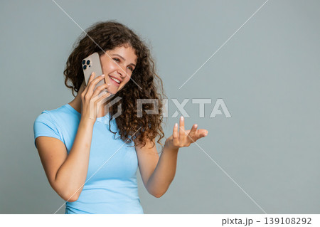 Woman talking smartphone phone call emotionally gesturing hands expressive animated conversation Woman talking smartphone phone call emotionally gesturing hands expressive animated conversation 139108292