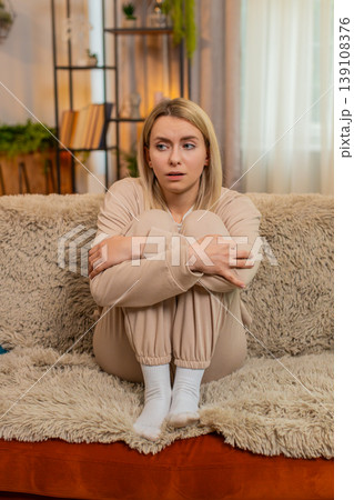 Adult sad woman showing visible stress, tension and emotional irritated, fatigue at home on sofa 139108376