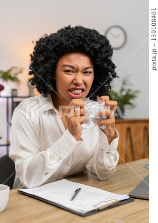 African American businesswoman crumples bill frustrated by mistake throws paper away upset at desk 139108401
