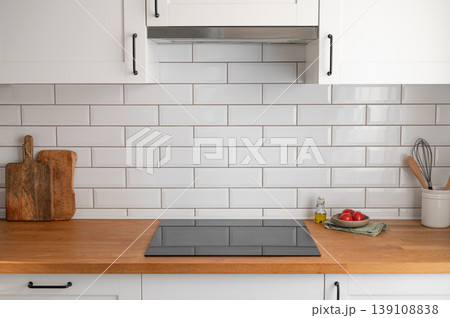 Modern kitchen wooden countertop with stove and tiled wall background. Modern kitchen wooden countertop with stove and tiled wall background. 139108838