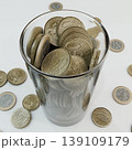 euro coins in a glass cup isolated on white background 139109179