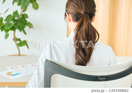 オフィスでデスクワークをする女性ビジネスパーソンの後ろ姿・ポニーテールのスーツ姿の会社員 オフィスでデスクワークをする女性ビジネスパーソンの後ろ姿・ポニーテールのスーツ姿の会社員 139109662
