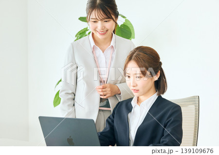 オフィスでノートパソコンを見ながら打ち合わせをする二人の若い女性ビジネスパーソン・先輩と後輩の業務指 139109676