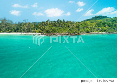 Beautiful tropical island view from the sea with crystal clear water and a rocky beach. Beautiful tropical island view from the sea with crystal clear water and a rocky beach. 139109798