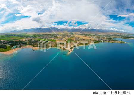Aerial view of blue Issyk-Kul lake and mountain landscape with resort Aerial view of blue Issyk-Kul lake and mountain landscape with resort 139109871