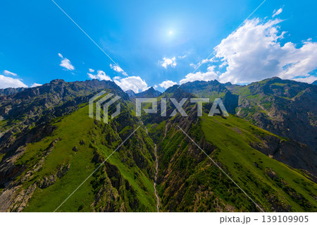 Majestic Rocky Mountain Range with Waterfall and Green Slopes 139109905