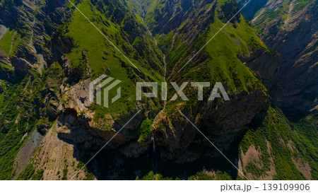 Aerial view of steep green mountainous slopes with waterfall Aerial view of steep green mountainous slopes with waterfall 139109906