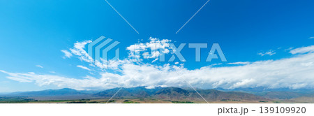 Panoramic view of rolling hills under vast blue sky Panoramic view of rolling hills under vast blue sky 139109920