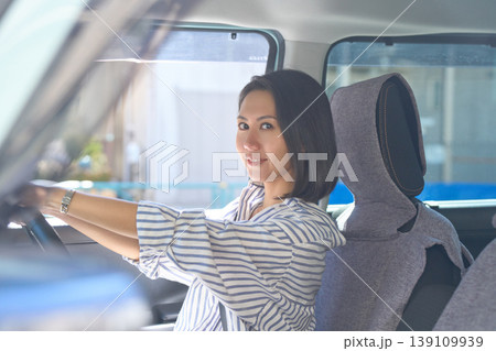 自動車の運転席でハンドルを握り、カメラ目線で微笑む日本人女性 自動車の運転席でハンドルを握り、カメラ目線で微笑む日本人女性 139109939