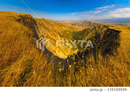 Panoramic view of eroded canyon cliffs and dry grass hills in Kyrgyzstan landscape 139109999