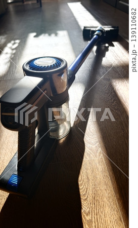 Vacuum cleaner on wooden floor during bright daytime light in living room Vacuum cleaner on wooden floor during bright daytime light in living room 139110682