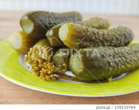 Fresh pickles on a green plate with herbs in a kitchen setting Fresh pickles on a green plate with herbs in a kitchen setting 139110764