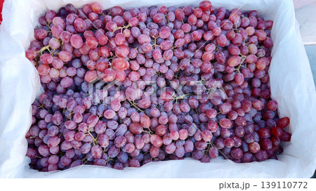 Fresh grapes are displayed in a container at the local market for sale 139110772