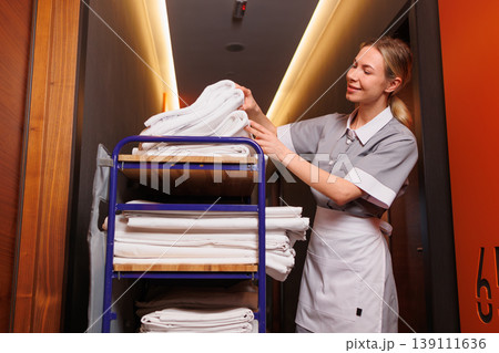 Hotel Maid Arranging Fresh Towels on Housekeeping Cart Hotel Maid Arranging Fresh Towels on Housekeeping Cart 139111636