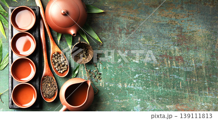 Assorted Loose Leaf Teas with Clay Teapot and Teacups on Rustic Surface 139111813