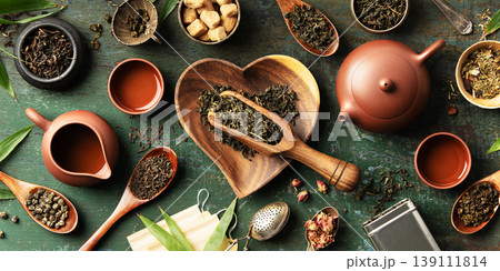 Tea Ingredients and Teaware with Heart-Shaped Bowl on Rustic Background 139111814