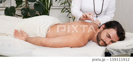 Reflexology. Treatment of back pain and tightness with acupuncture needles for a male patient Reflexology. Treatment of back pain and tightness with acupuncture needles for a male patient 139111912