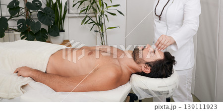 Acupuncture treatment to relieve stress and relax the body man. Male patient lying down while having acupuncture therapy and treat headache 139111923