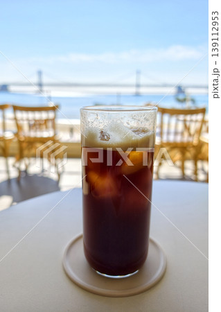 Ice Americano on cafe table with view of Gwangan bridge, Busan 139112953