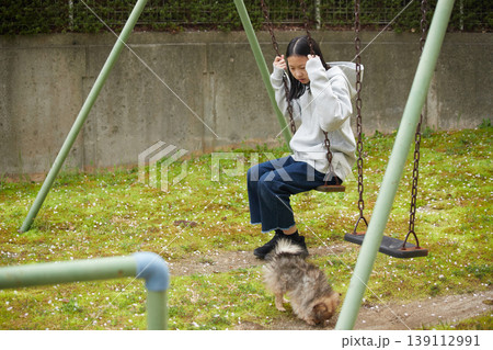 春のマンションの公園で可愛いポメラニアンの子犬と遊んでいる女の子の子供の様子 春のマンションの公園で可愛いポメラニアンの子犬と遊んでいる女の子の子供の様子 139112991