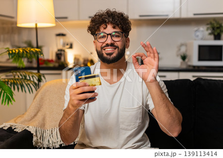 Arabian man confirms online payment with card on smartphone checks discount smiles stores e receipt 139113414