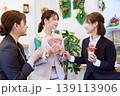 カフェでクレープやパフェを手に楽しく会話する3人の若い女性ビジネスウーマン・仕事帰りのスイーツタイム 139113906